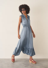 Woman wearing a dusky blue satin midi dress standing against a plain background