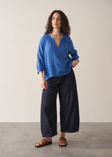 Woman wearing cobalt blue cotton top and blue jeans