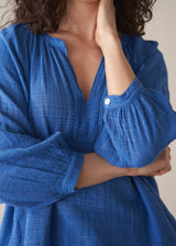 Woman wearing cobalt blue cotton top and blue jeans