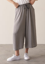 Woman wearing white shirt and stripe wide leg cropped trousers