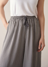 Woman wearing white shirt and stripe wide leg cropped trousers