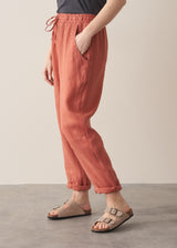 Woman wearing terracotta linen trousers with beige sandals