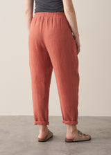 Woman wearing terracotta linen trousers with beige sandals