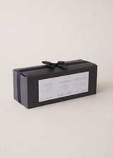 Set of three scented candles in a black bow tied gift box, on a beige background