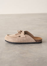 Pair of beige moccasin slipper shoes on a grey concrete surface