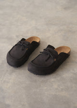 Pair of black moccasin slipper shoes on a grey concrete surface