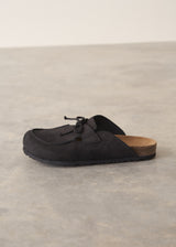 Pair of black moccasin slipper shoes on a grey concrete surface