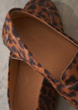 Pair of leopard print loafers on a grey surface