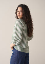 Woman wearing green stripe top with blue jeans