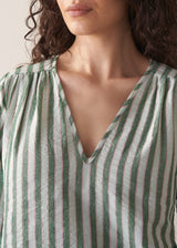 Woman wearing green stripe top with blue jeans