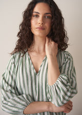 Woman wearing green stripe top with blue jeans