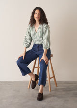 Woman wearing green stripe top with blue jeans
