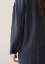 Woman wearing dark navy trench coat with blue jeans