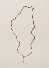 A smokey grey crystal bead necklace, finished with white, quartz heart pendant, on a beige background