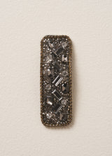 Decorative hair clip with crystal gemstones on a beige background