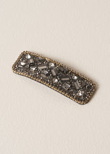 Decorative hair clip with crystal gemstones on a beige background