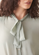 Light green blouse with a tie neckline worn by a person