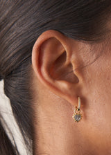 Close up of woman wearing crystal gold heart hoop earrings