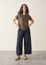 Woman wearing khaki stripe t-shirt and blue wide leg jeans