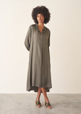 Woman wearing a khaki satin midi dress with khaki strappy sandals.