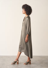 Woman wearing a khaki satin midi dress with khaki strappy sandals.