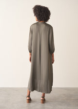 Woman wearing a khaki satin midi dress with khaki strappy sandals.