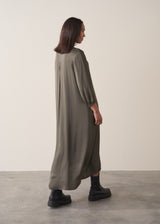 Woman wearing a long dark green satin dress