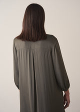 Woman wearing a long dark green satin dress