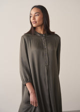 Woman wearing a long dark green satin dress