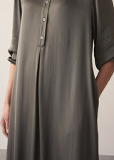 Woman wearing a long dark green satin dress