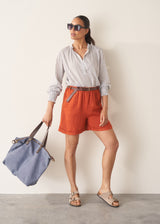 Blue bag with brown leather handles on a beige background