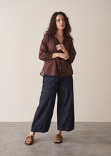Woman wearing a sheer brown cotton shirt with blue jeans