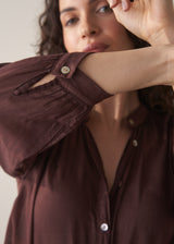 Woman wearing a sheer brown cotton shirt with blue jeans