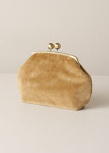A tan suede kiss-lock clutch bag with two gold-tone pearl clasp buttons, set against a neutral light beige background.