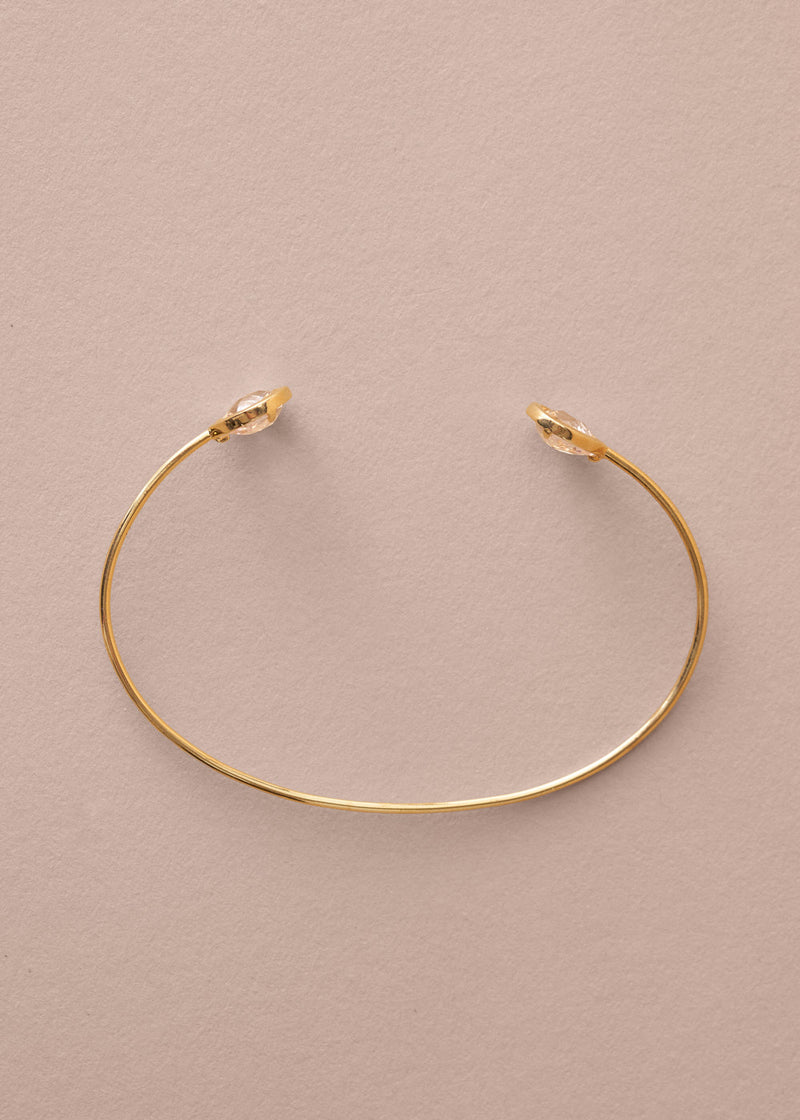 Gold bracelet on a beige background