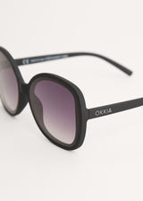 A pair of oversized sunglasses with black frames and blue lenses