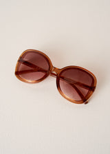 Brown sunglasses on a light beige background