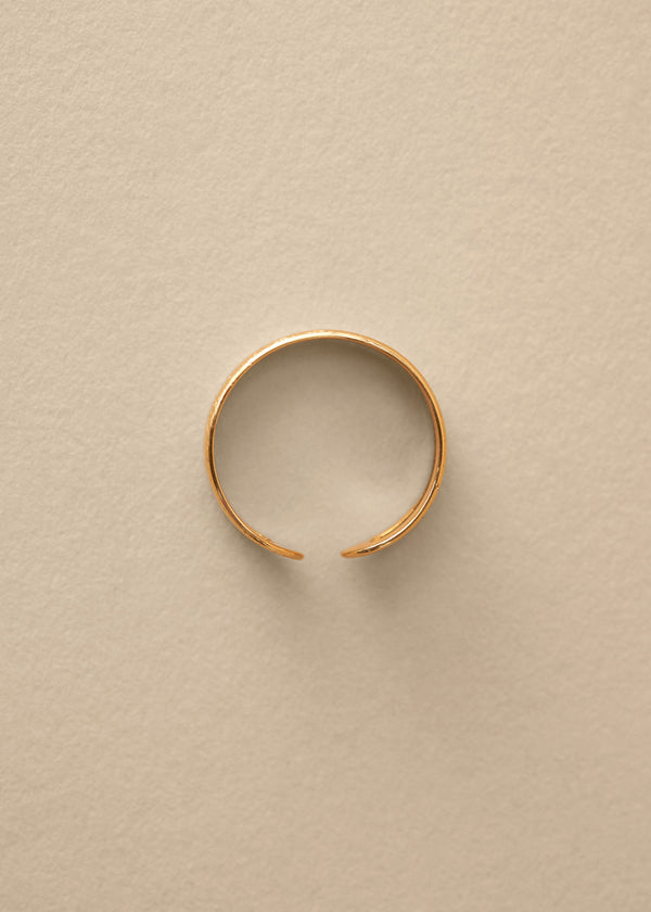 Gold bangle on a beige background