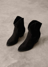 Pair of black suede ankle boots on a gray surface