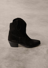 Black suede cowboy boot on a gray background