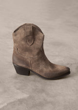 Brown suede cowboy boot on a gray background