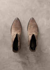 Pair of brown suede ankle boots on a textured gray surface