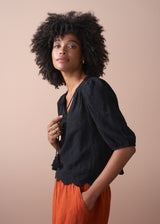 Black embroidered top with scallop hem and tassel details