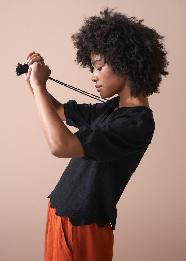 Black embroidered top with scallop hem and tassel details
