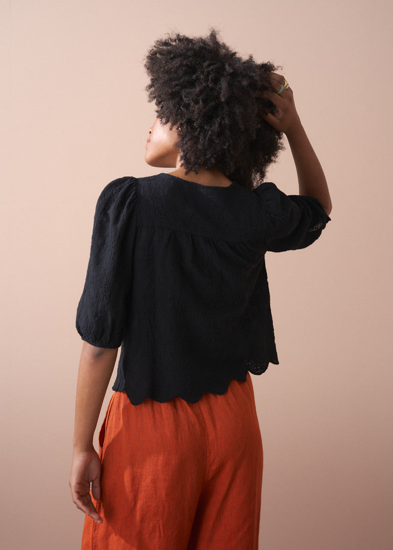 Black embroidered top with scallop hem and tassel details