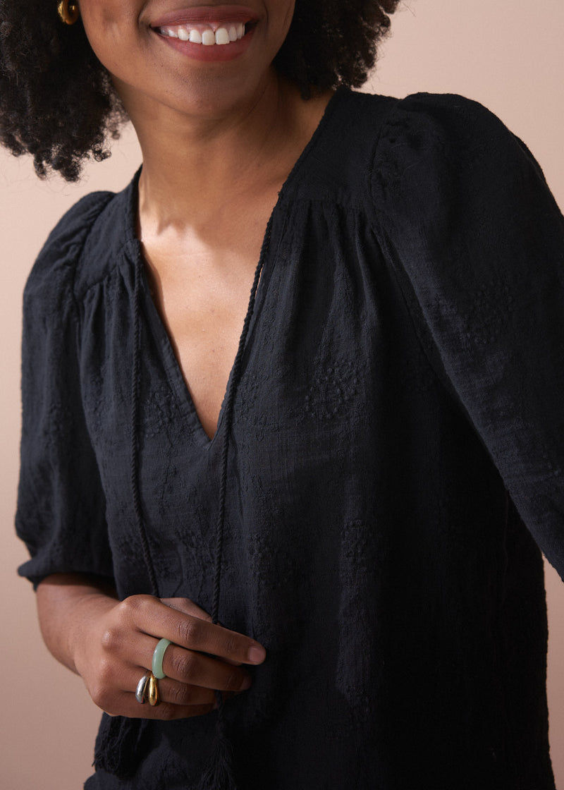Black embroidered top with scallop hem and tassel details