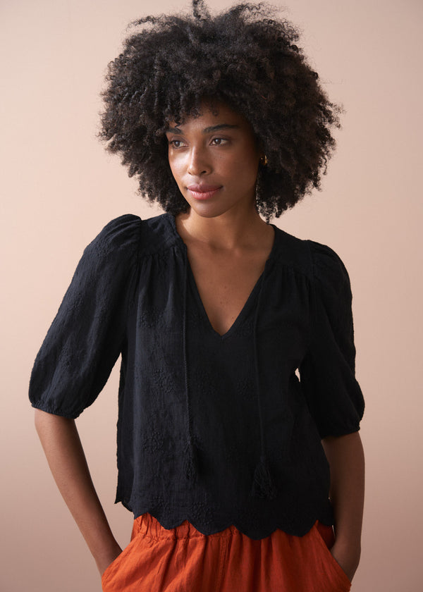 Black embroidered top with scallop hem and tassel details