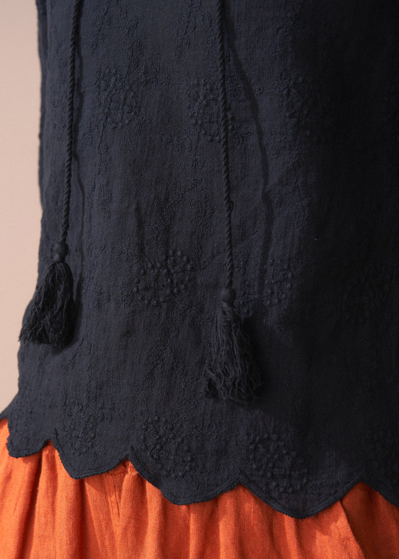 Black embroidered top with scallop hem and tassel details