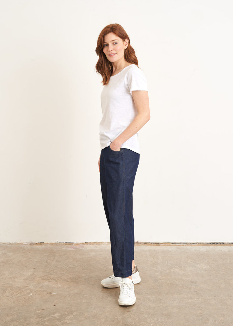 A model wearing a white shortsleeved top with blue jeans