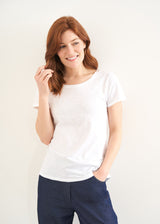 A model wearing a white shortsleeved top with blue jeans